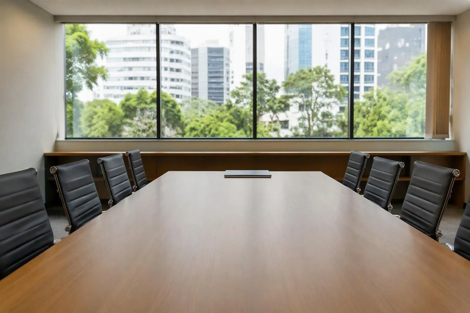 Sala de reunião vazia com cadeiras alinhadas e a mesa limpa